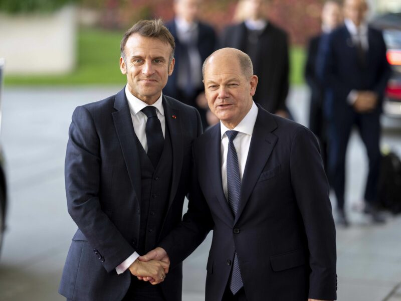 Photo of French President Emmanuel Macron shaking hands with German Chancellor Olaf Scholz in Berlin on Oct. 18.