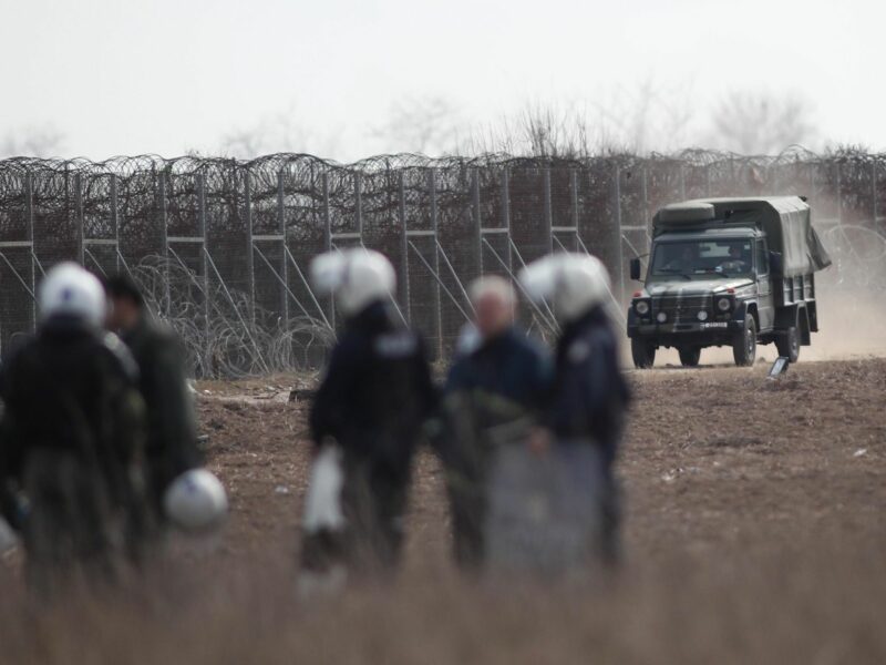 photo of Greek riot police patrol near Evros river, on the border with Turke