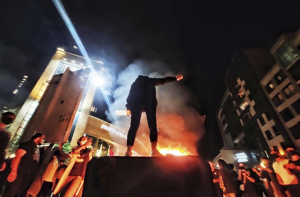 photo of Iranian woman remove their headscarf and clash with police during protest for Mahsa Amini, a woman who died after being arrested by the Islamic republic's ''morality police'', in Tehran.