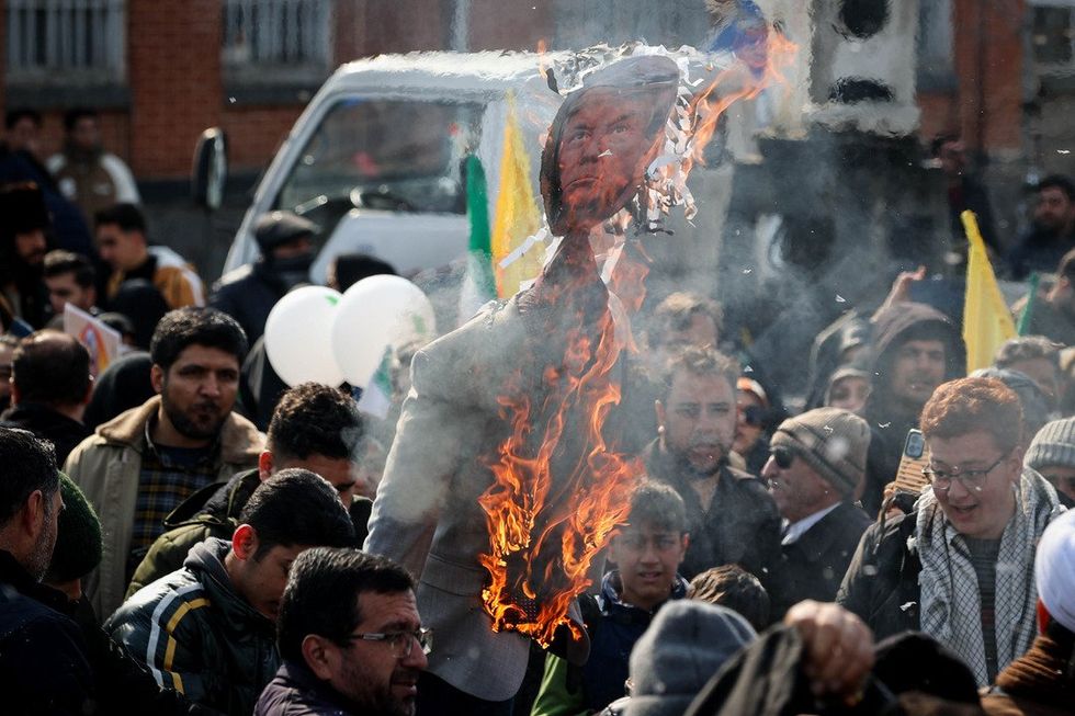 Photo of Iranians burning a poster of US President Donald Trump during a rally to commemorate the 46th anniversary of the 1979 Islamic Revolution.