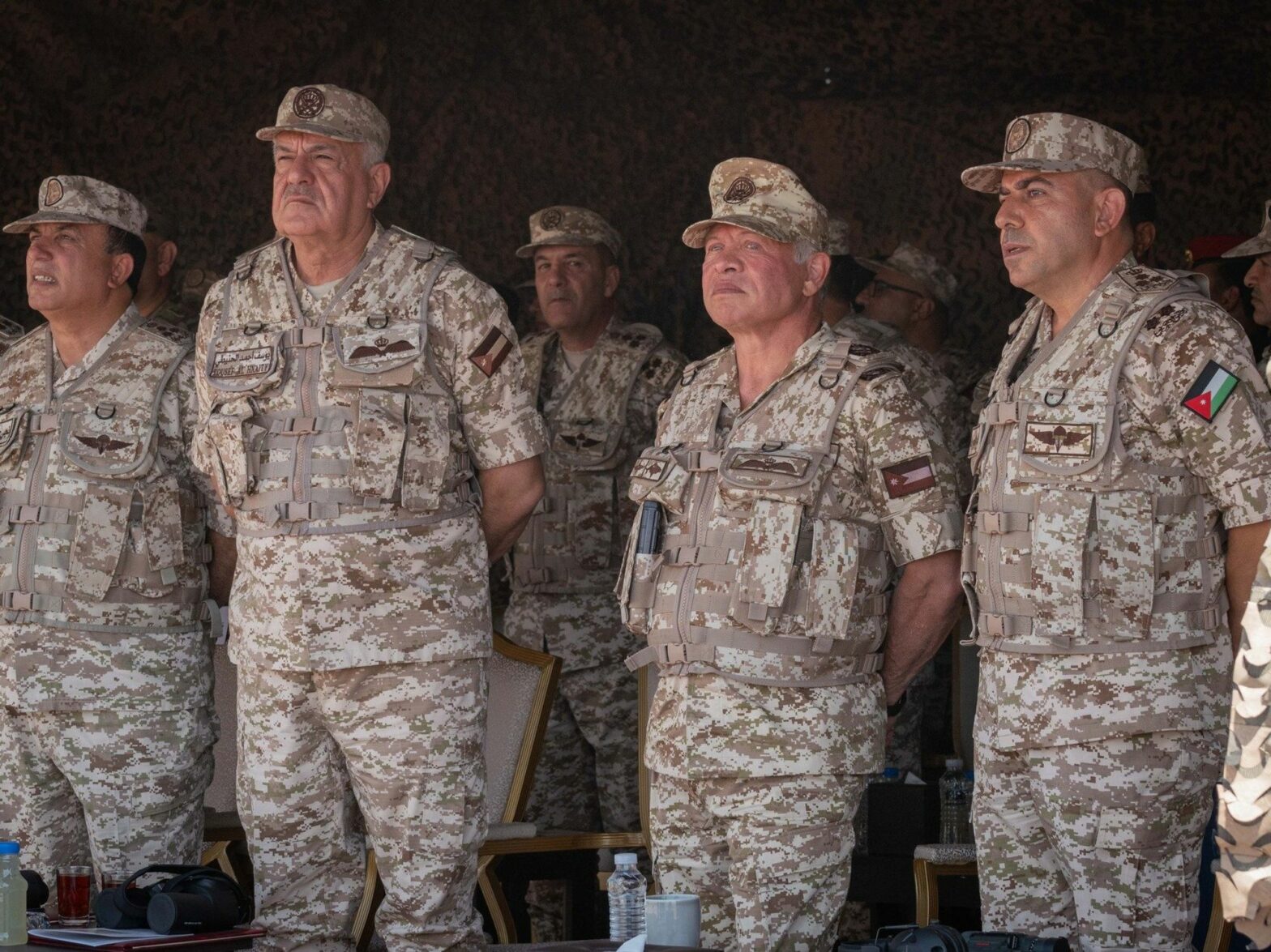 Photo of Jordan's King Abdullah II in military uniform surveying military exercises.