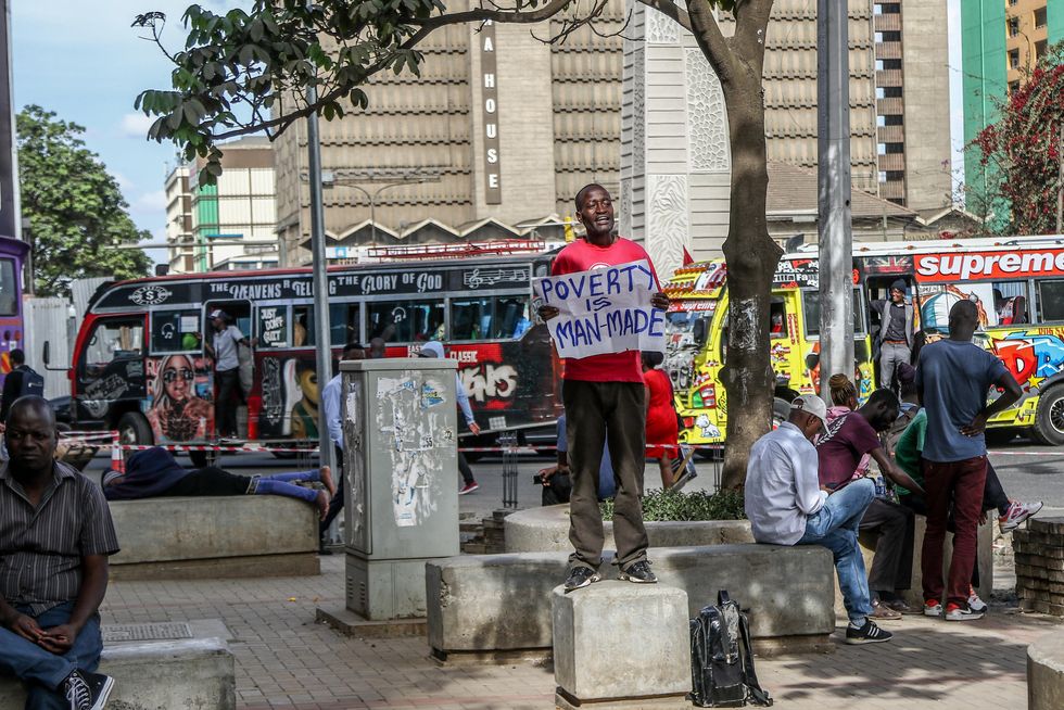 Photo of Julius Kamau, a vocal Kenyan human rights activist speaks while holding a poster that reads "poverty is manmade" on the Streets of Nairobi Central Business District.