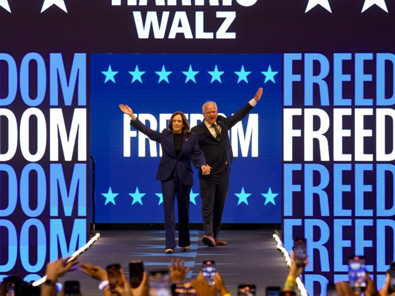 Photo of Kamala Harris and Tim Walz walking onstage at a campaign rally at Fiserv Forum in Milwaukee, Wisconsin on August 20.