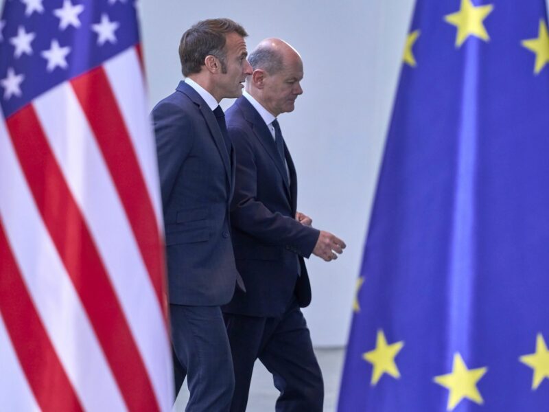 photo of macron and scholz between eu and u.s. flags