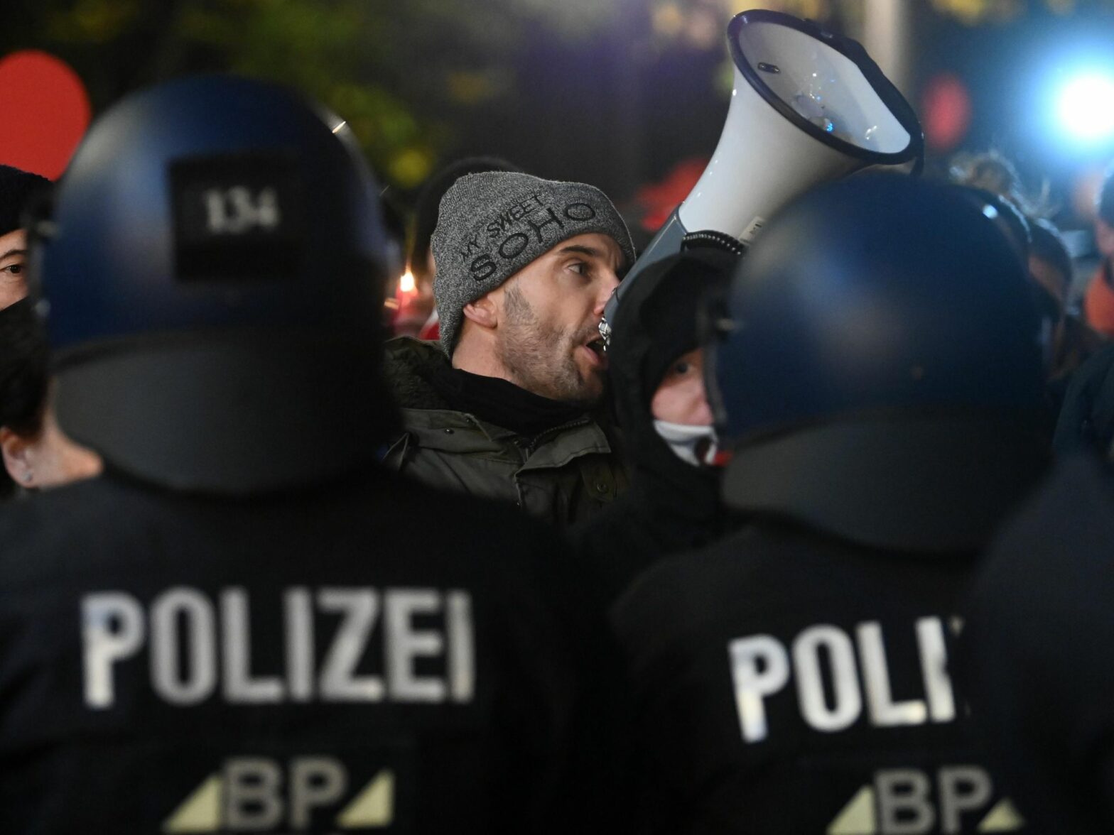 photo of man speaking in megaphone at protest in Saxony