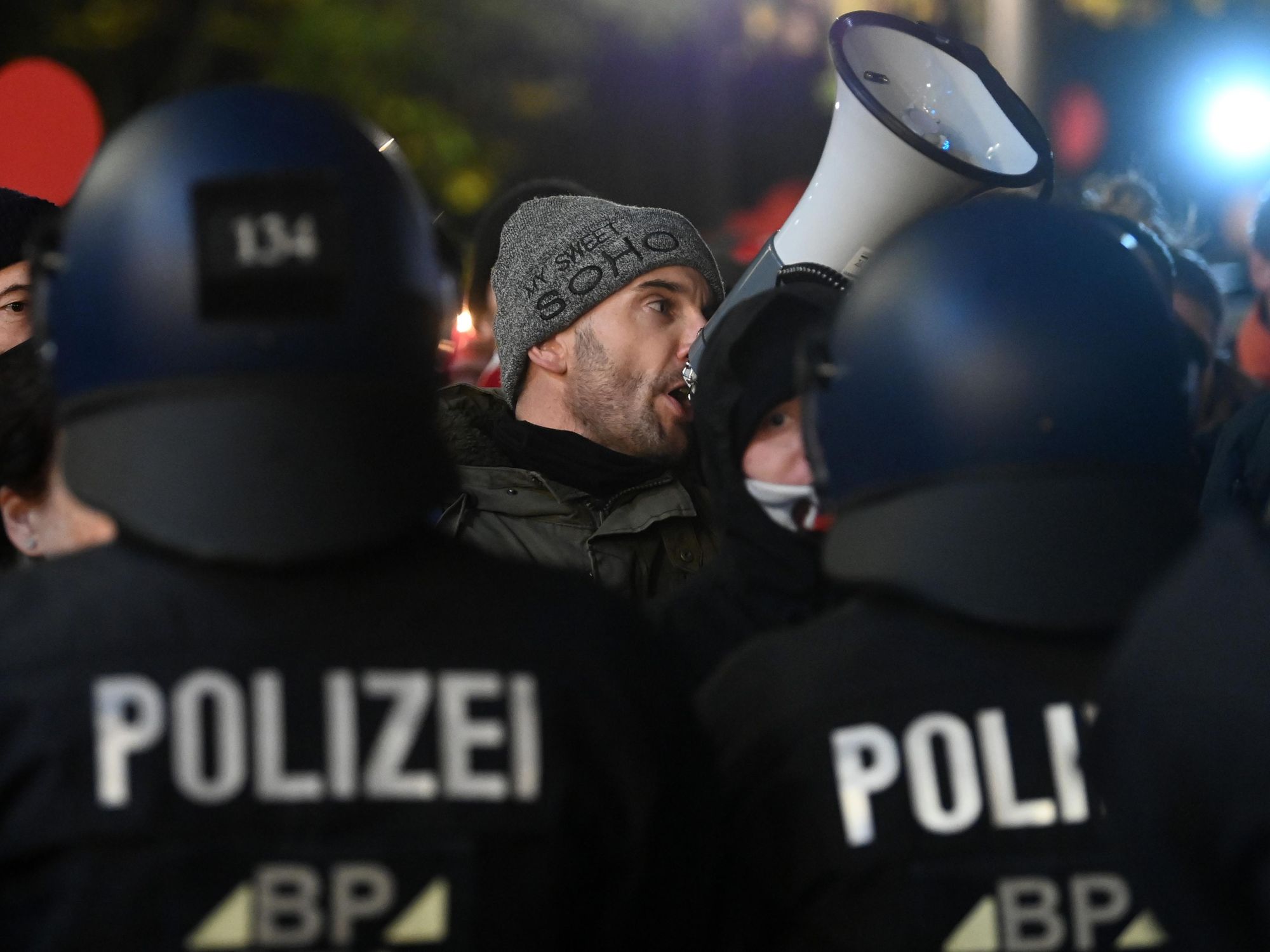 photo of man speaking in megaphone at protest in Saxony
