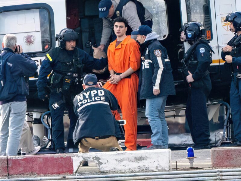 photo of mangione in orange jumpsuit getting off helicopter
