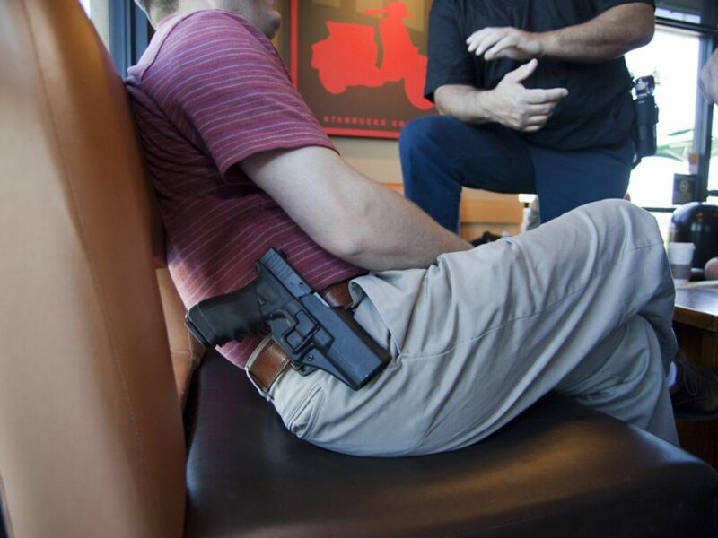 Photo of men carrying guns in holsters as they are chatting in a Starbucks coffee shop in Fullerton, California, U.S.
