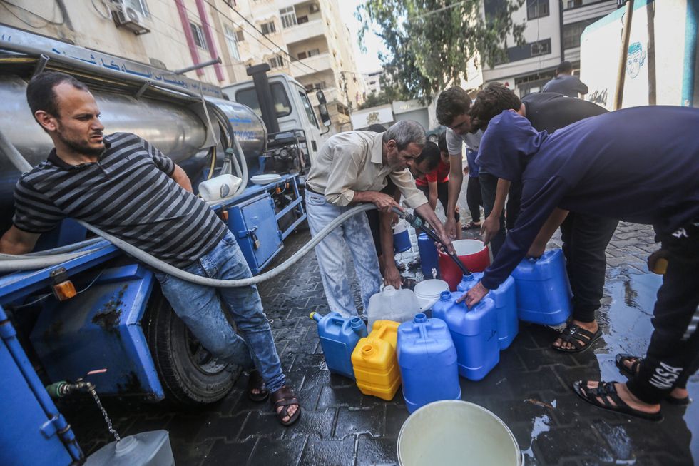 photo of men filling up jugs of water