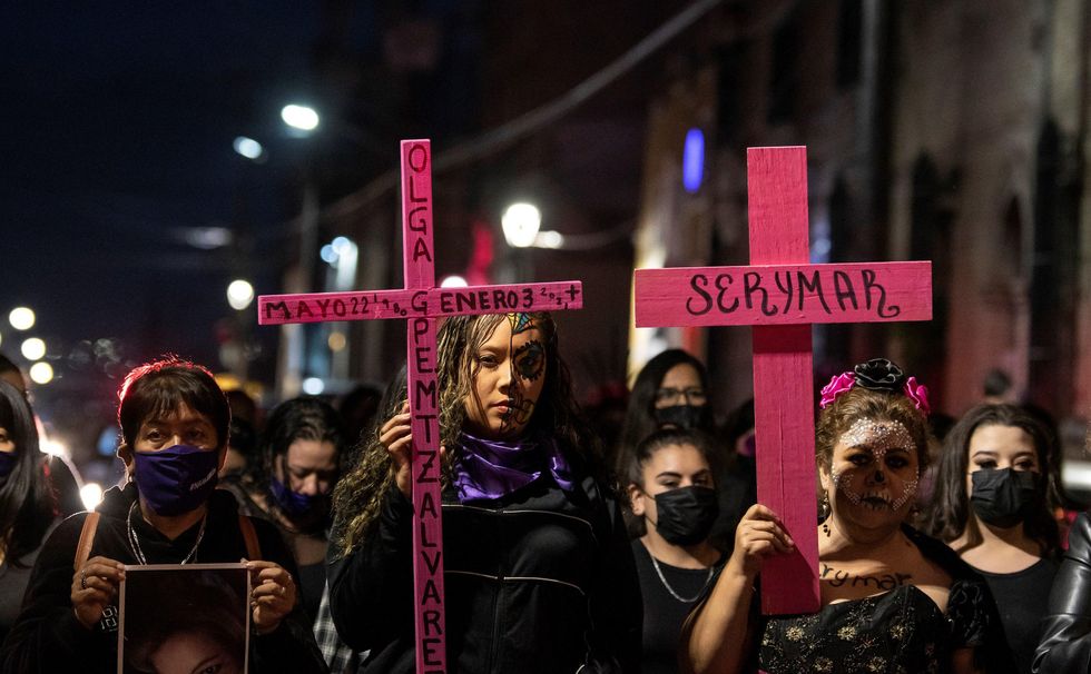 Photo of Mexican "Catrinas" carrying pink crosses during a silent procession in memory of the victims of femicide, on the Día de Muertos in Saltillo, Mexico. 02 November 2021.