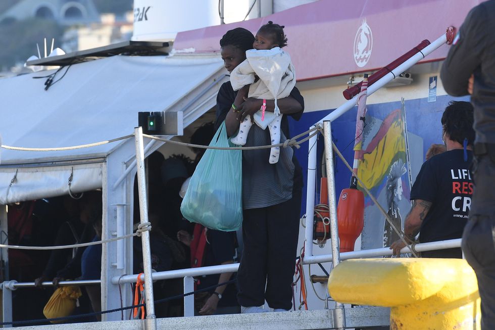Photo of migrants disembarking from a ship in southern Italy