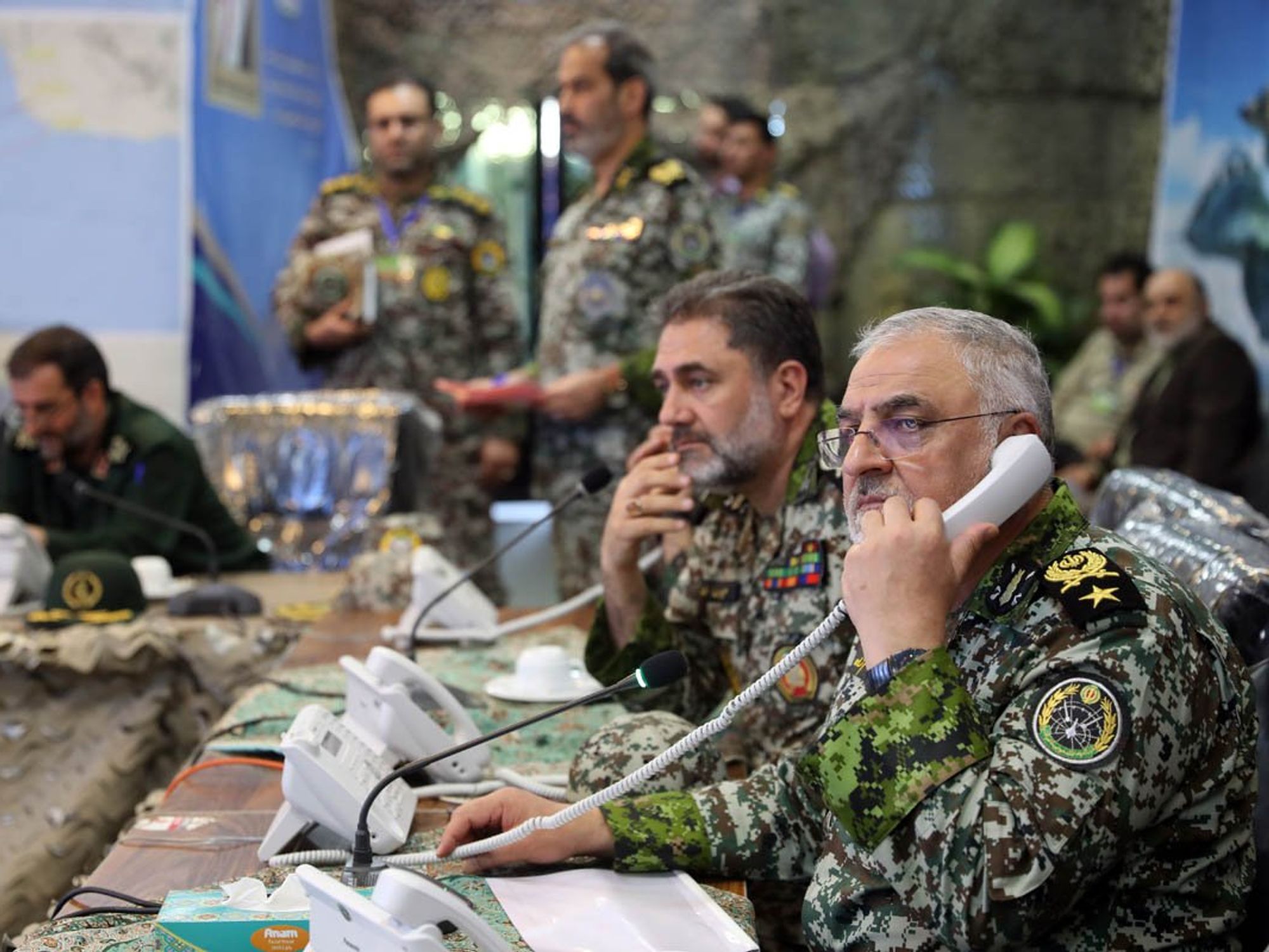 Photo of military personnel on a phone while monitoring something