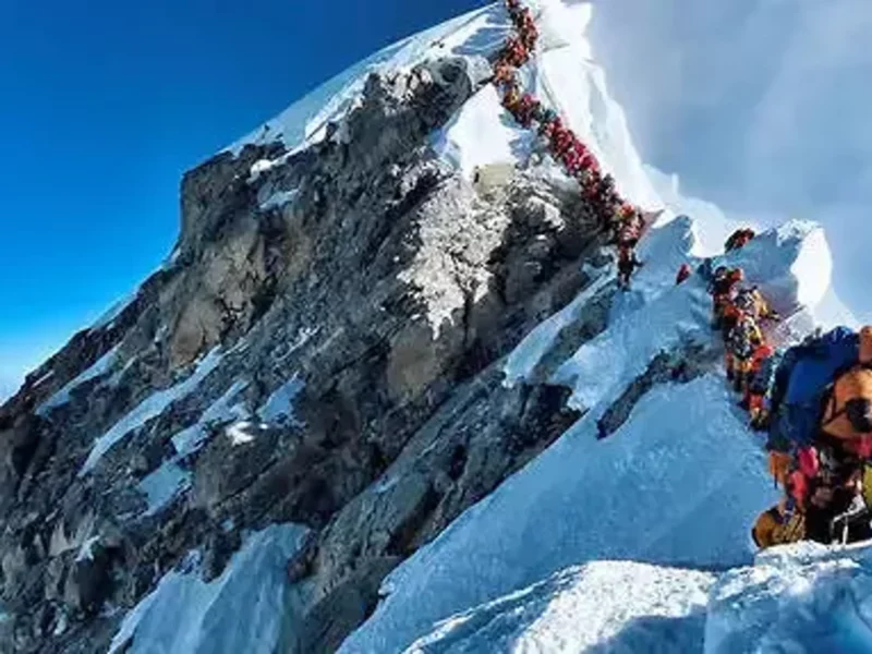 Photo of Mount Everest with lines of tourists waiting.