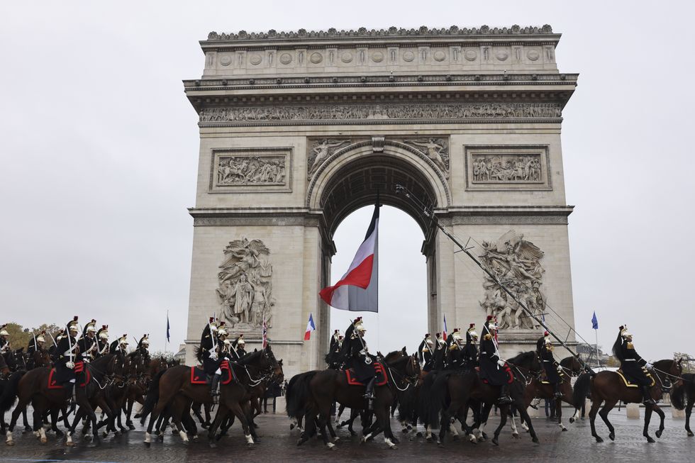 Photo of mounted guards parading on horseback near Paris' Arc de Triomphe on Nov. 11.