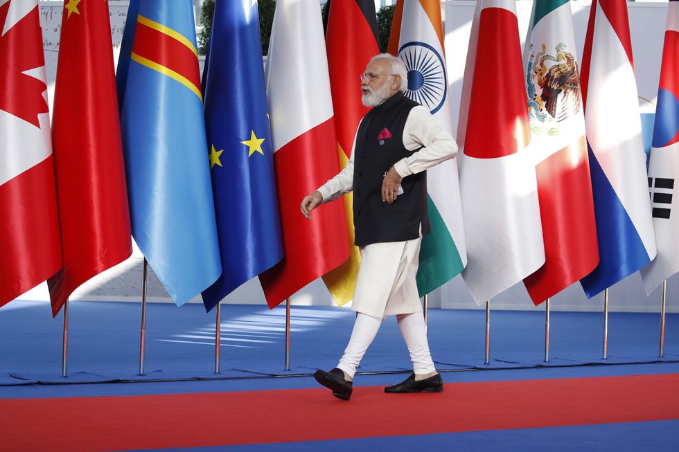Photo of Narendra Modi walking past flags