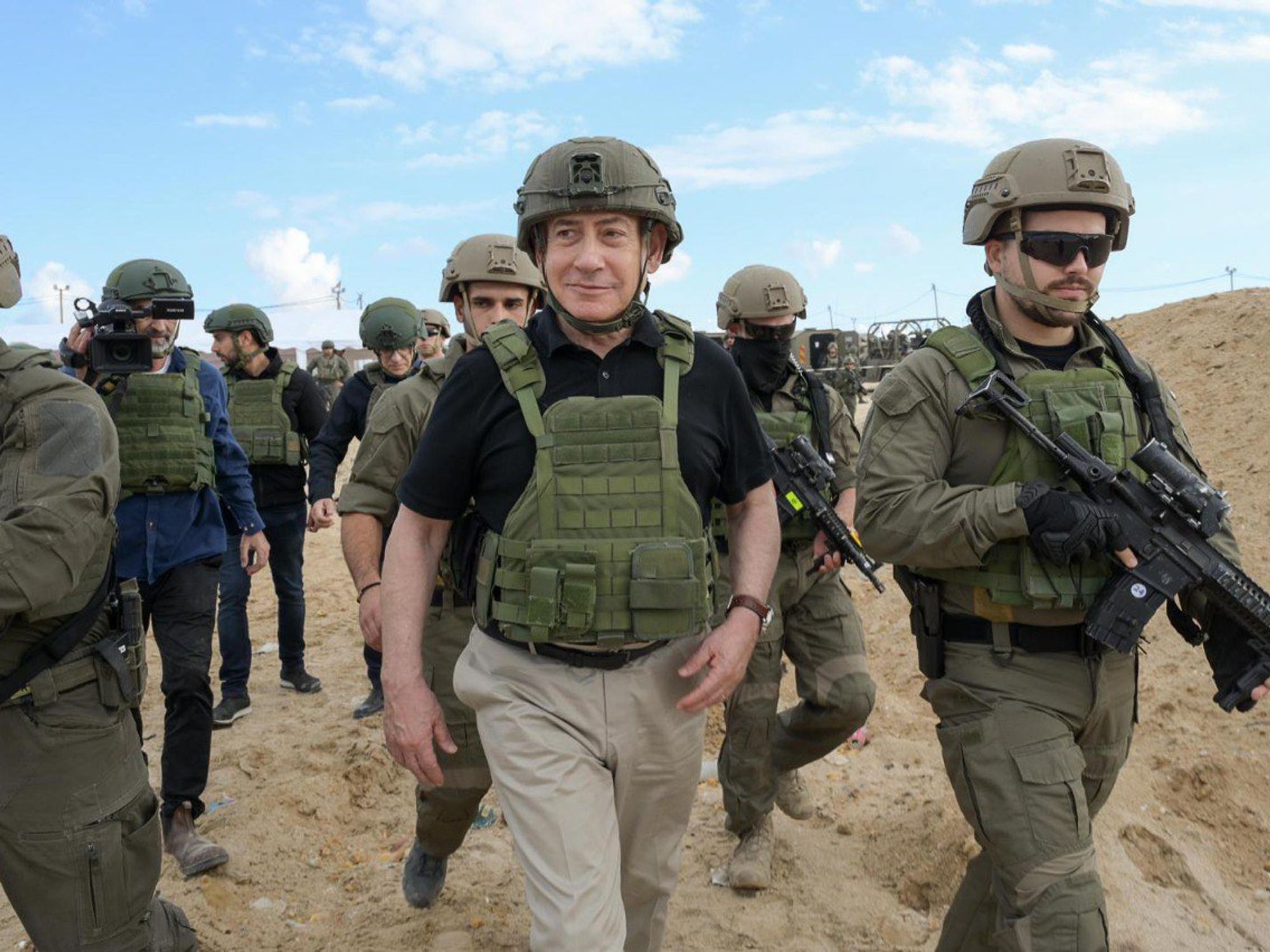 photo of Netanyahu in protective vest walking surrounded by soldiers