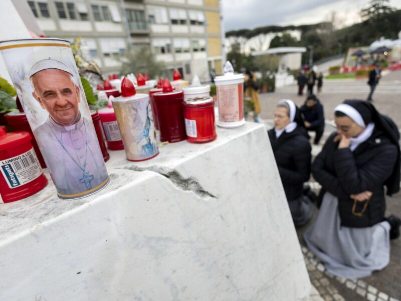 Photo of nuns praying near Rome's Gemelli Polyclinic, next to an altar with Pope Francis-themed candles