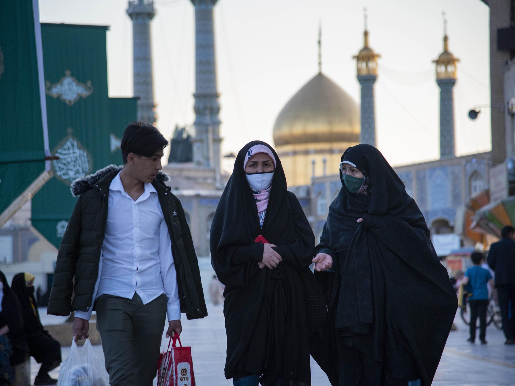 Photo of one man and two veiled women in Qom