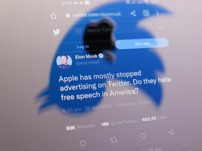 Photo of one of Elon Musk's tweet seen through the shape of Twitter's logo turned upside down