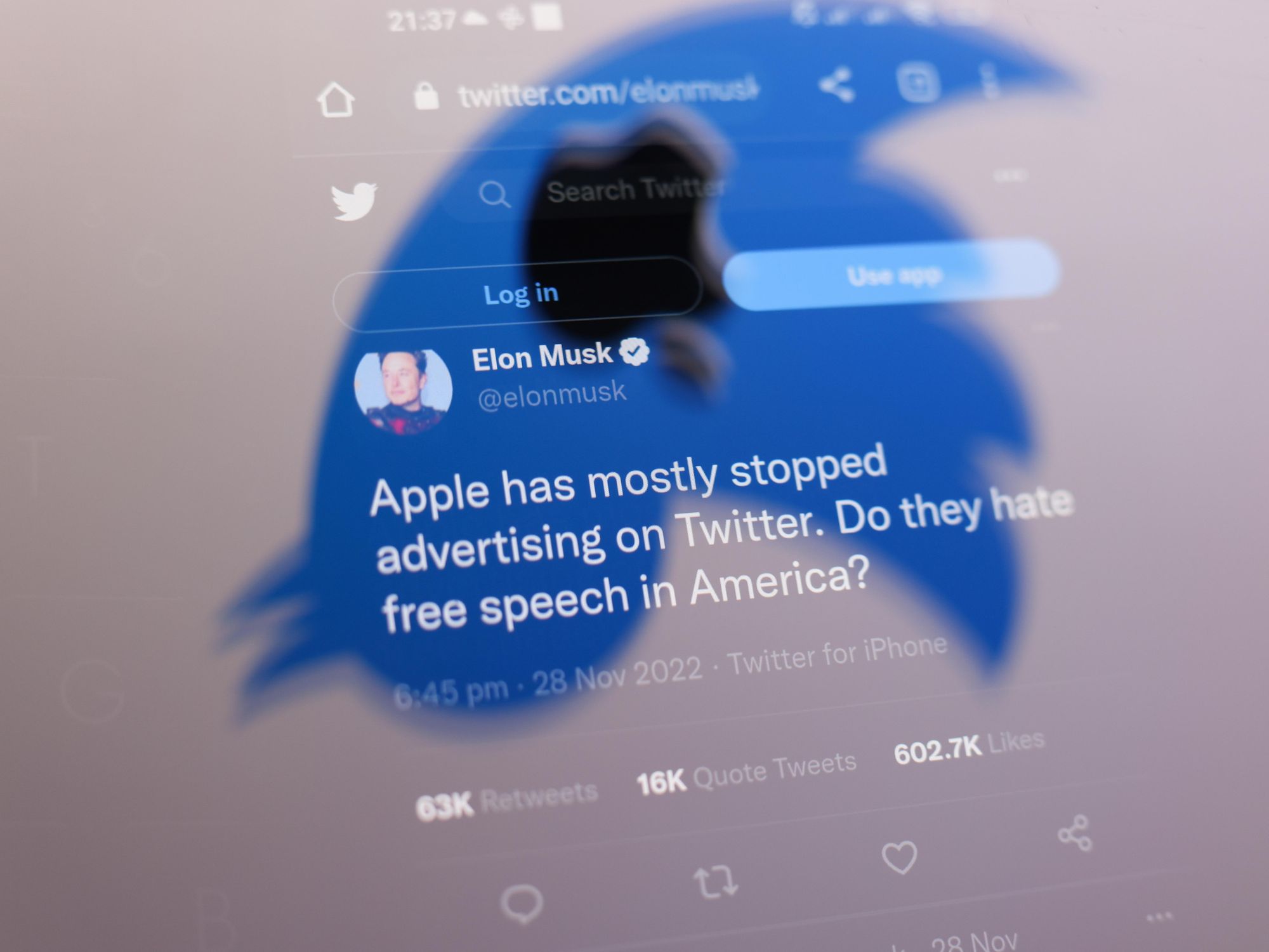 Photo of one of Elon Musk's tweet seen through the shape of Twitter's logo turned upside down