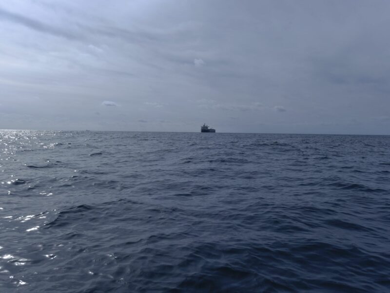 photo of open sea with a ship in the distance