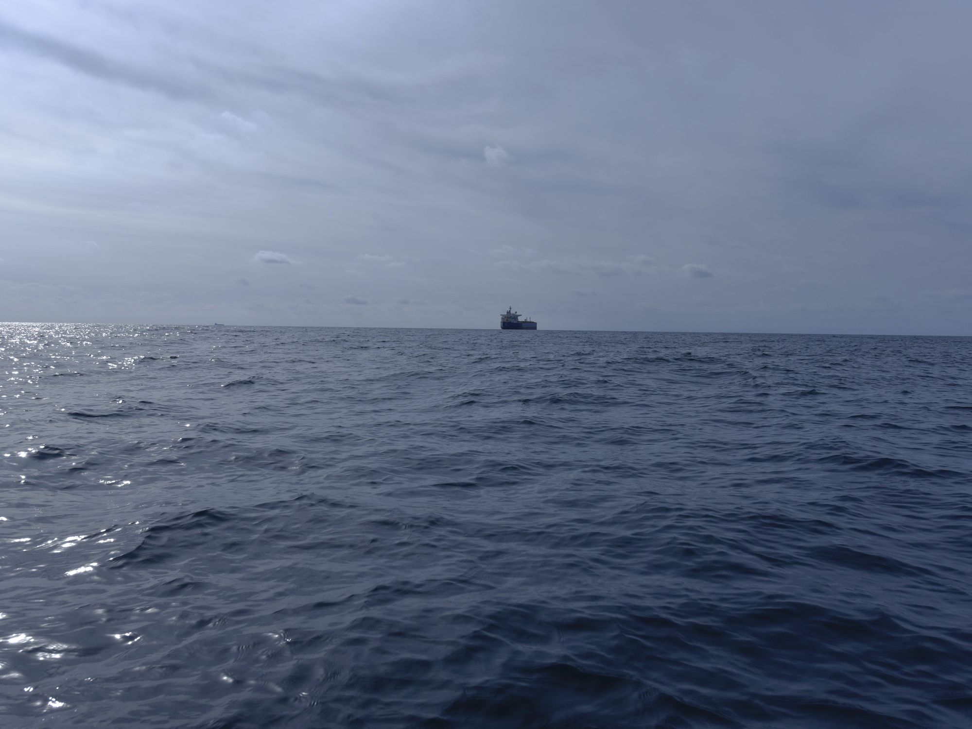 photo of open sea with a ship in the distance