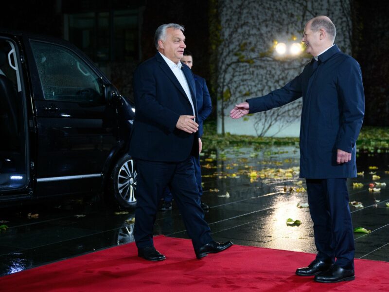 photo of orban walking toward sholz to shake hands