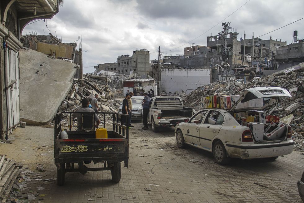 Photo of Palestinians fleeing Jabalia in vehicles amid the rubble.