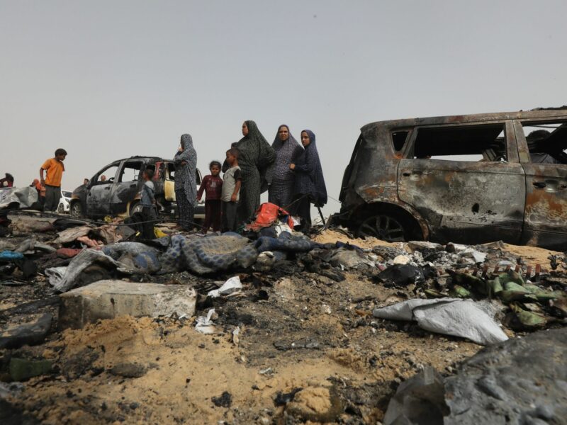 Photo of Palestinians looking at charred debris in Rafah, Gaza, after Israeli airstrikes on May 27