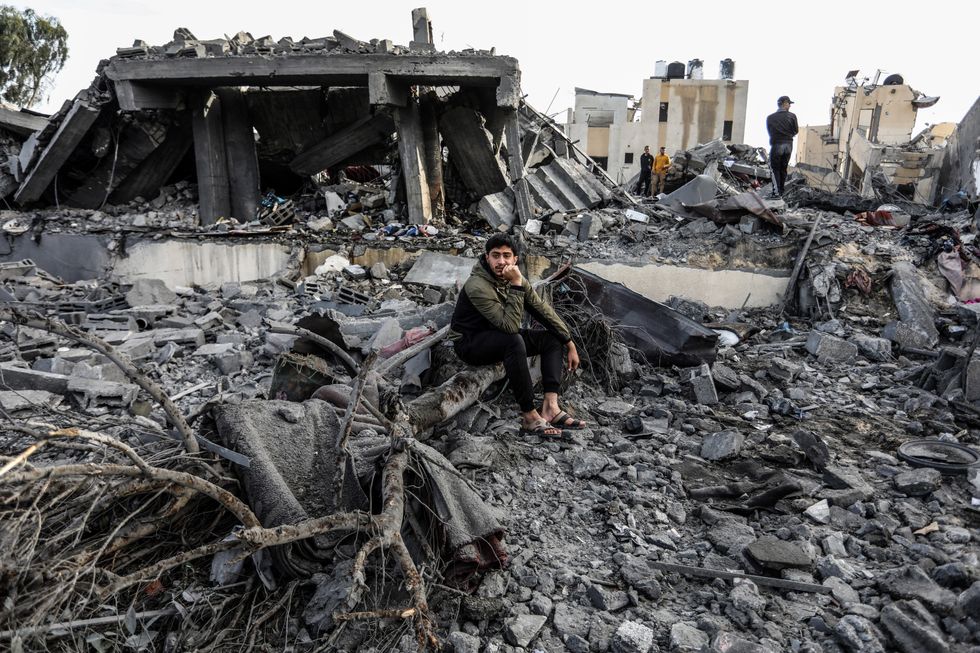 Photo of Palestinians standing among the rubble in Gaza