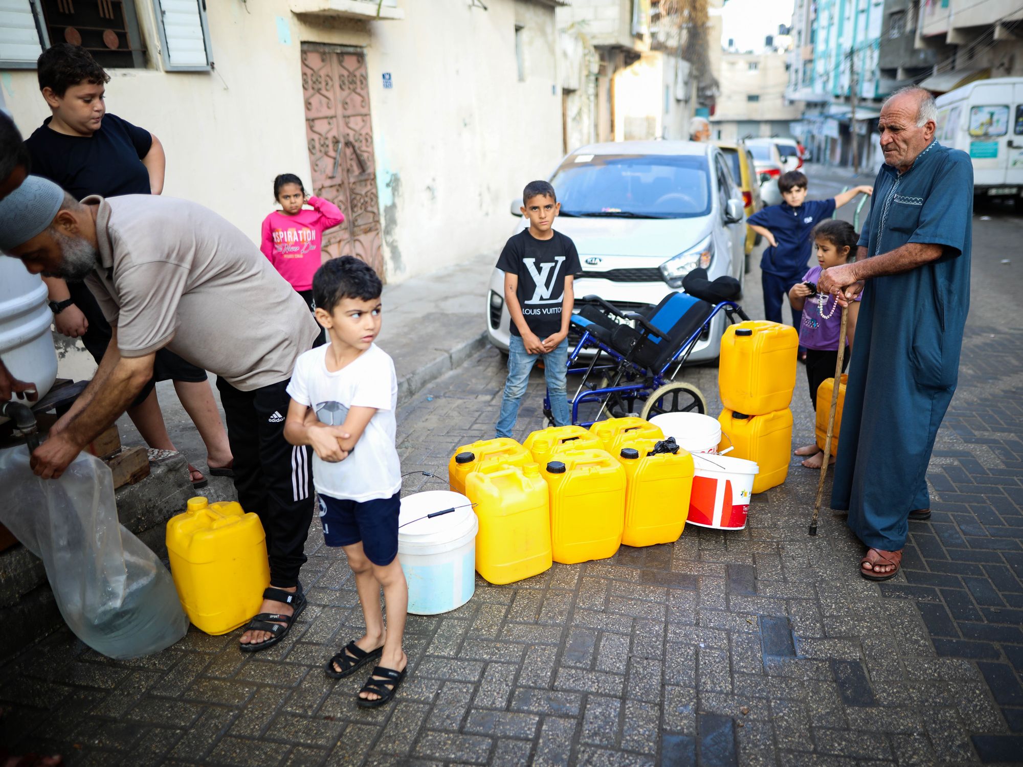 Photo of Palestinians waiting in line to collect clean water