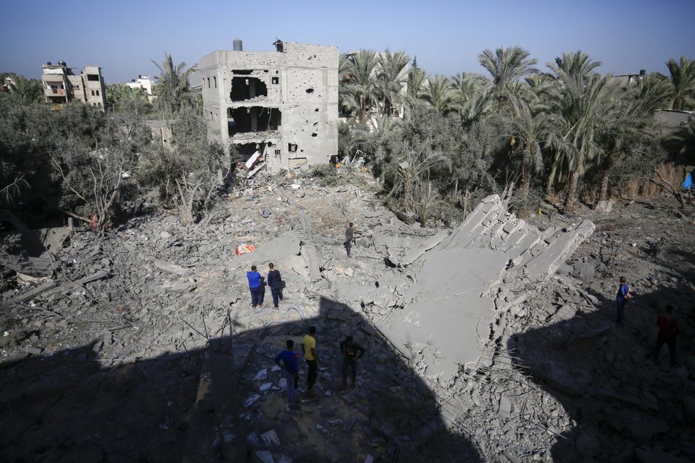 Photo of Palestinians walking amid the rubble in Gaza