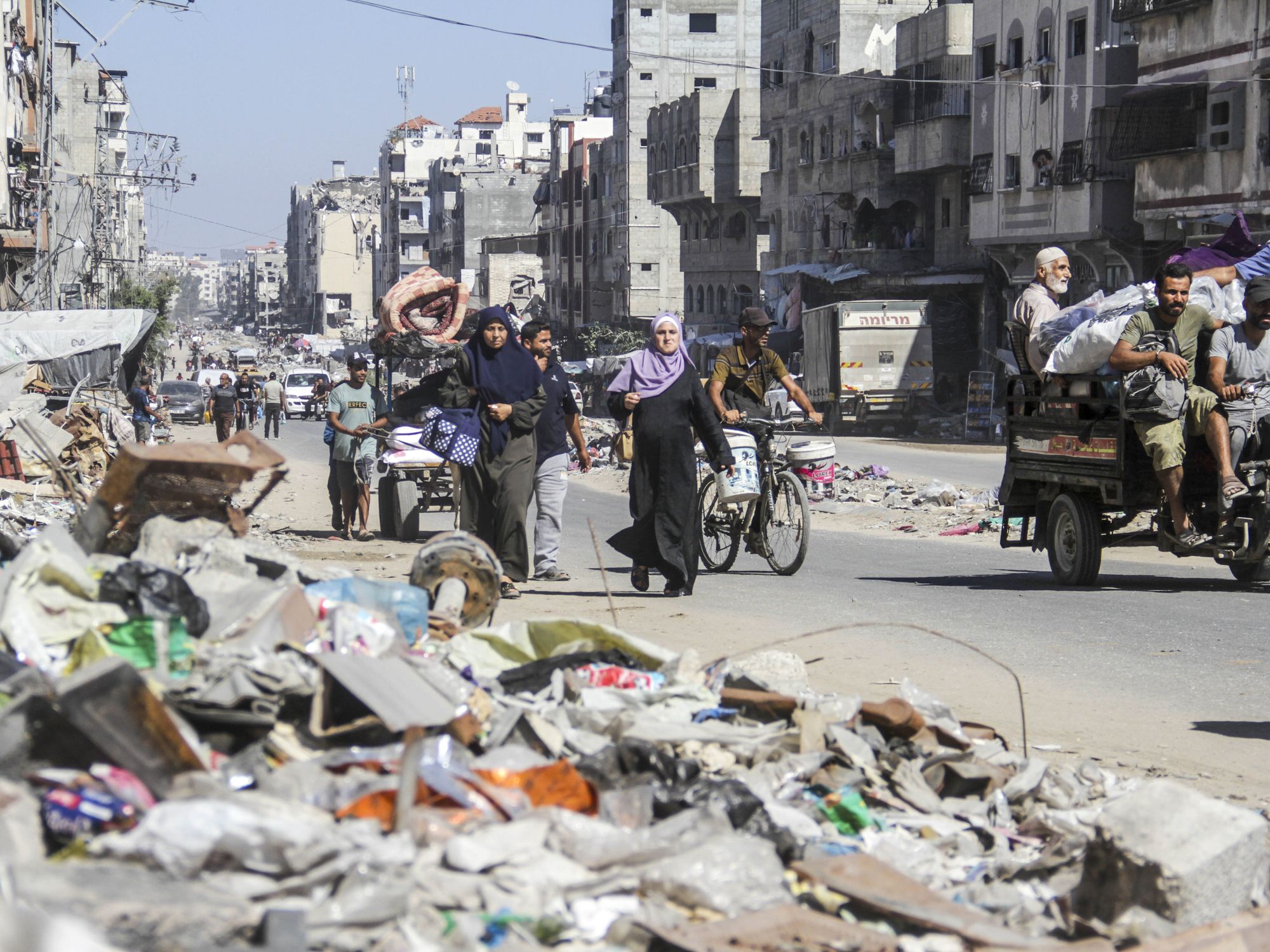Photo of Palestinians walking among the rubble while fleeing Northern Gaza.