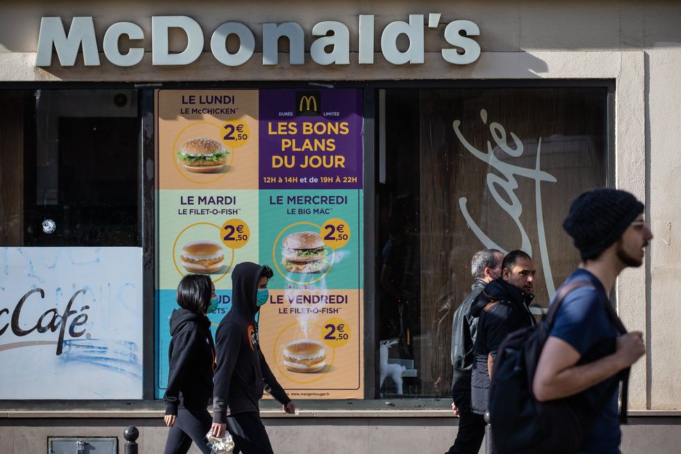 Photo of pedestrians walking past a McDonald's restaurant near Place de la Republique in Paris, France.