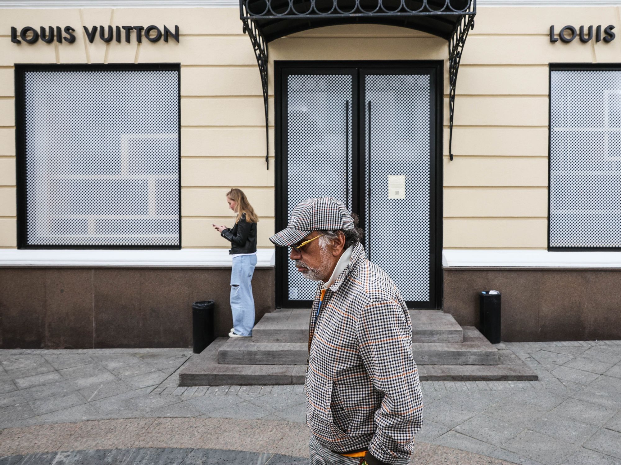 Photo of People are seen outside a closed shop of the French luxury brand Louis Vuitton that has suspended its operations in Russia due to Western anti-Russian sanctions.