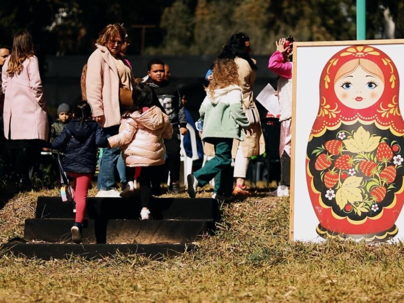 Photo of people attending a cultural Russian-themed event in Hammamet, Tunisia, walking past a framed picture of Russian nested dolls