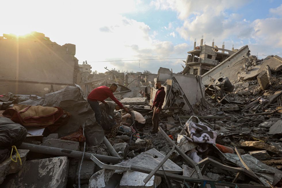 Photo of people collecting items from the rubble of a building destroyed in an Israeli attack in the Nuseirat refugee camp, central Gaza Strip, on Nov. 1.