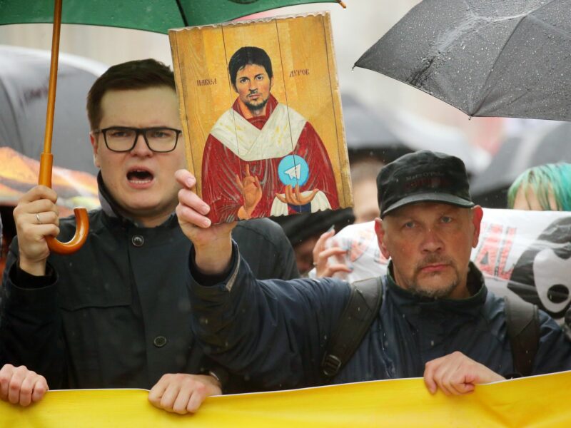 photo of people demonstrating and holding up an image of Pavel Durov