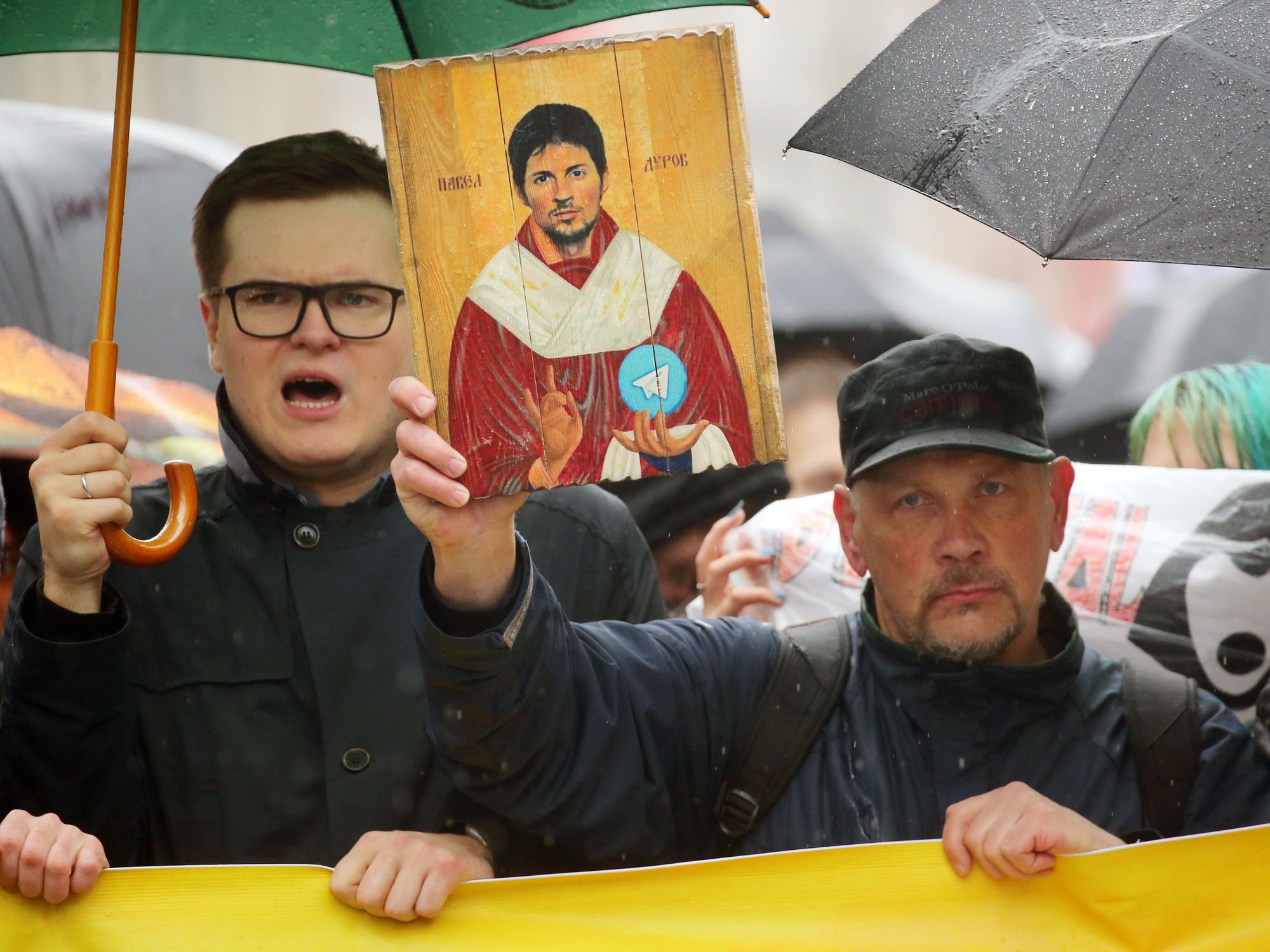 photo of people demonstrating and holding up an image of Pavel Durov