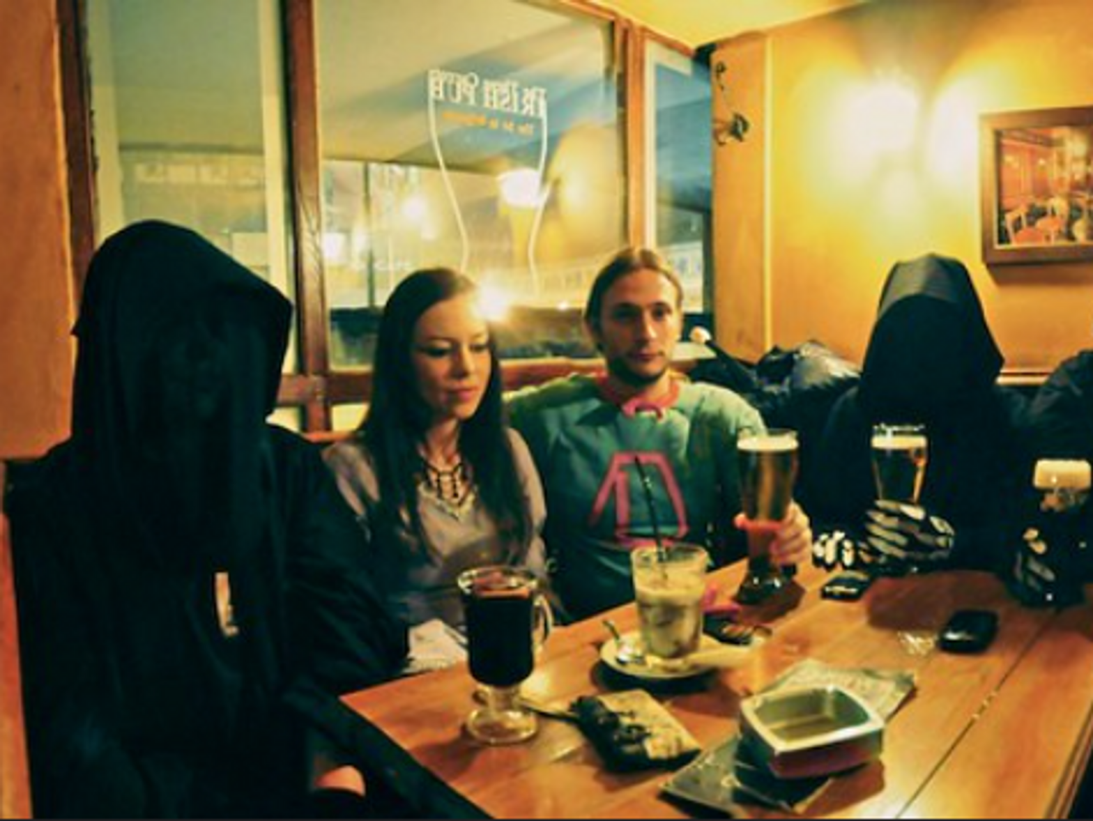 Photo of people dressed as Nazgûls drinking with a couple in a pub