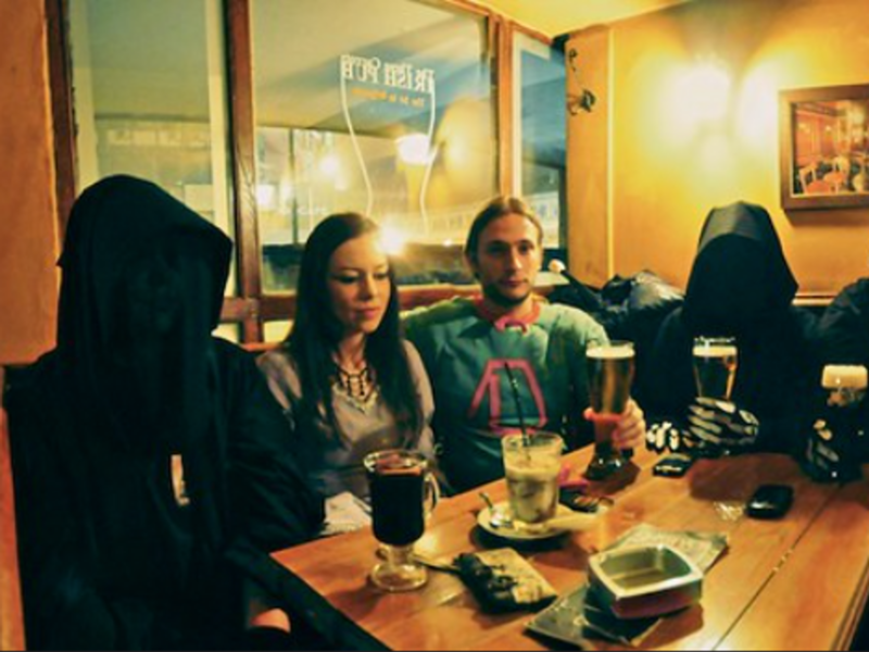Photo of people dressed as Nazgûls drinking with a couple in a pub