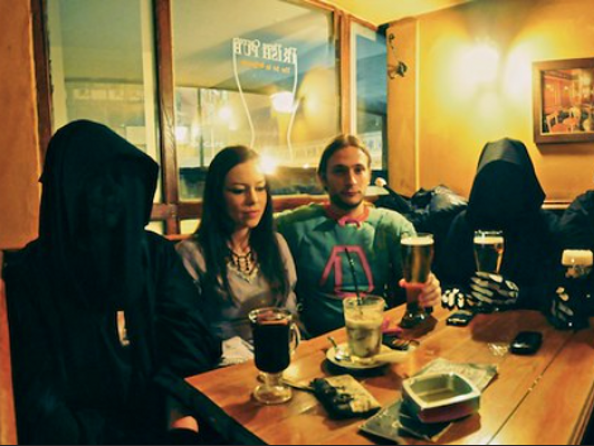 Photo of people dressed as Nazgûls drinking with a couple in a pub