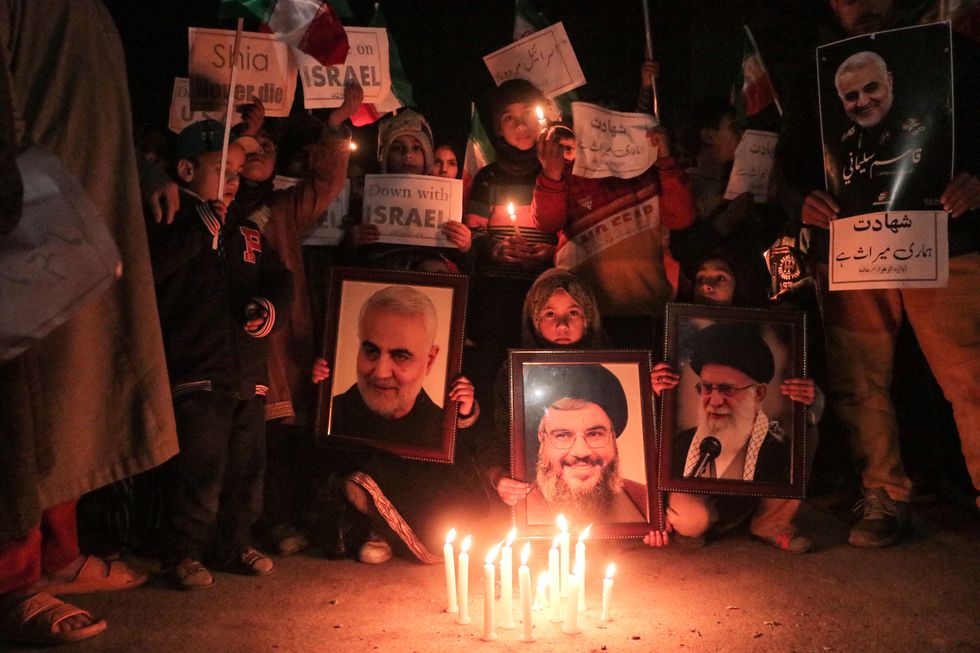 Photo of people gathering to participate in a candle light vigil as they chant anti-Israel and anti-US slogans