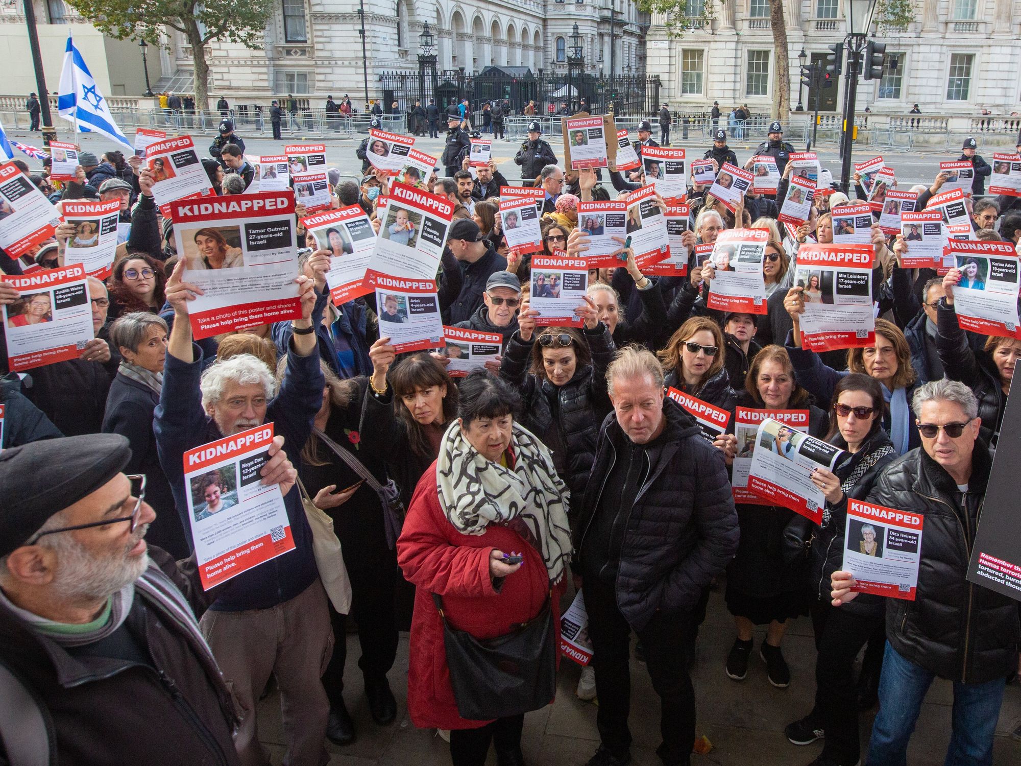 Photo of people holding pictures of hostages held by Hamas during a march in London
