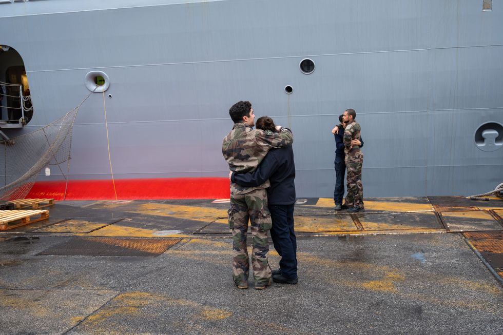 photo of people hugging in front of a ship