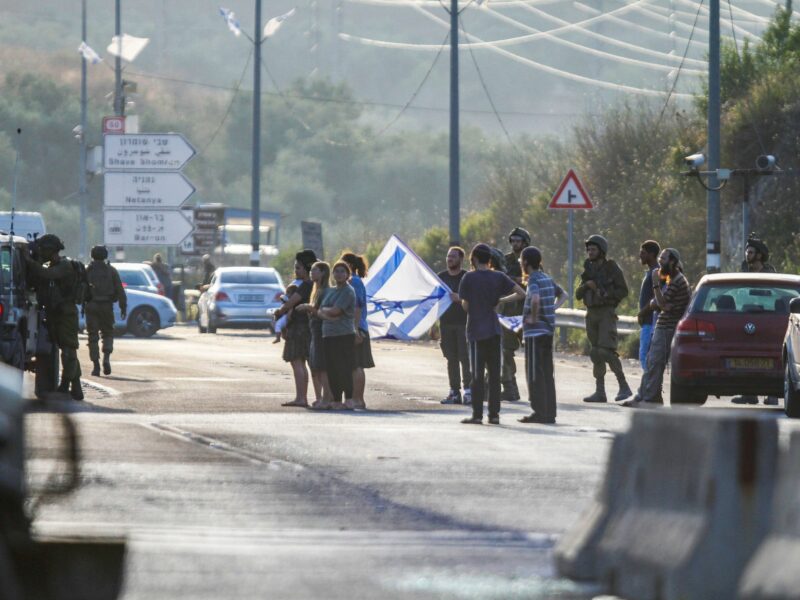 photo of people in a road with an israeli flag