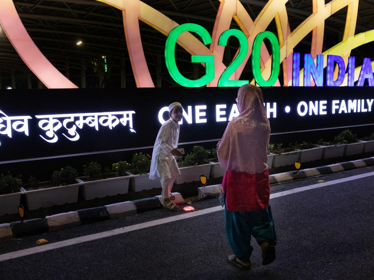 photo of people in front of neon sign of g20 India