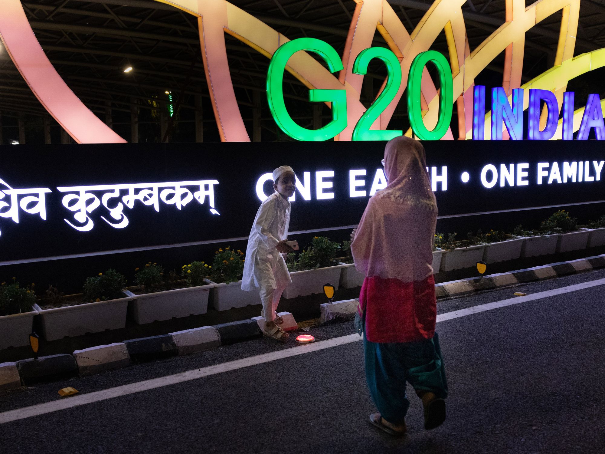 photo of people in front of neon sign of g20 India