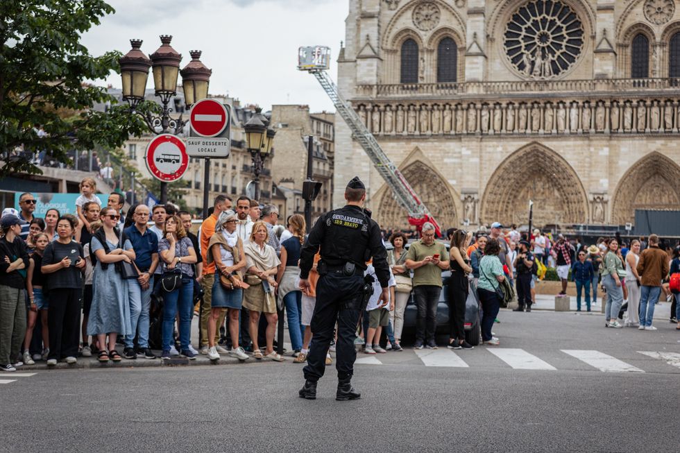 photo of people in front of notre dame with police watching