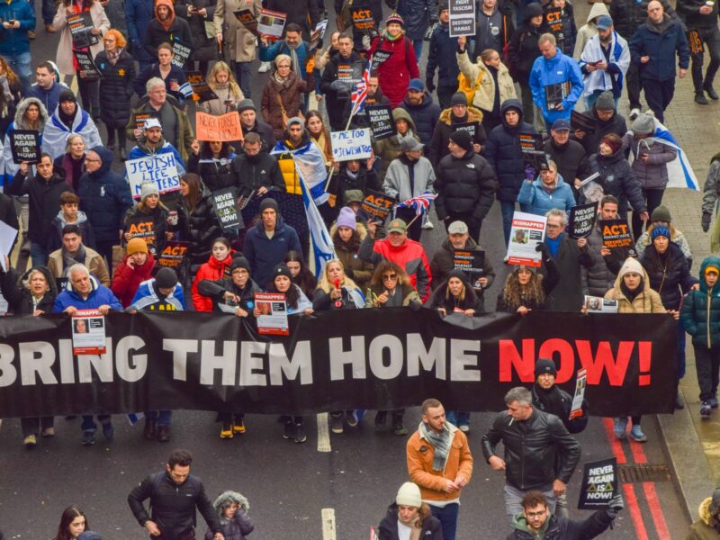 photo of people marching with the sign Bring Them Home Now
